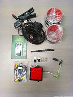 Top view of the car accessories bundle components on a table, including the fan, LED lights, wiring, antenna, and clips.