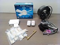 All items shown together on a table including socket fan light in box, USB converters, gold cabinet handle, heating cable, and shower head