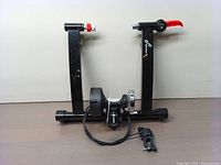 Front view of the black magnetic bike trainer stand showing the frame, flywheel, resistance control cable, and quick-release lever.