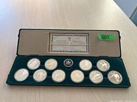 Full set in green velvet presentation case with ten coins, medallion, and certificate
