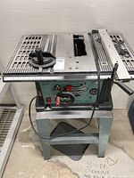 Front and top view of bench saw on stand showing controls and tabletop and fence