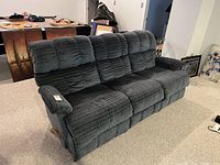 Front view of three-seat reclining sofa showing overall shape, upholstery pattern and seat arrangement.