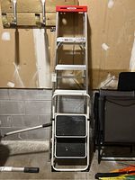 Front view of the two ladders together against a wall, showing size comparison.