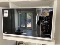 Front view of Panasonic microwave showing mirrored door with control panel on the right side.