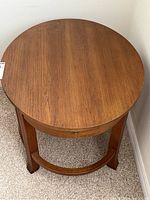 Top view of the round wooden side table showing wood grain and edge shape.