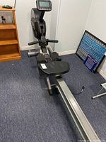Full view of black and silver Spirit rowing machine showing digital console, sliding seat, footrests