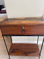 Full view of pine box on metal frame with lower shelf, showing the front lock with no key.