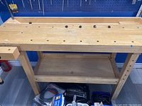 Front view of bench showing full top surface, vise, and lower shelf