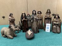 Full set of nativity scene figures arranged including Mary, Joseph, Baby Jesus, three wise men, angel, shepherd, and animals