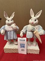 Both Easter bunny figurines shown side by side on a neutral background, highlighting the full pair and their bases.