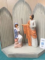 Full view of Mary and Joseph resin figures positioned on wood sanctuary backdrop with antiqued green finish and vertical rusted nail marks