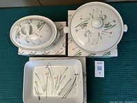 Full view of three pieces in the Mikasa Bake and Serve Sketchbook pattern, showing round casserole, oval tureen, and rectangular lasagna dish on their boxes.