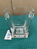 Front and side view of clear square glass ice bucket with handle and open top, showing smooth surface and design.