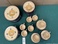 Overall set of stacked dinner plates, salad plates, bowls, cups and saucers displayed on table