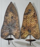 Pair of vintage large metal leaf-shaped wall mount candle holders with copper patina, showing both items together and the details of the wear and texture.
