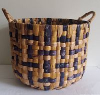 Large woven basket with dual handles showing full basket and shape.