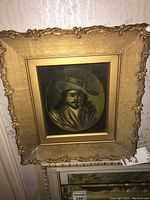 Framed portrait of a man with a wide-brimmed hat in an ornate gold frame