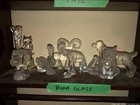 Group of six Boda glass animal figurines on shelf