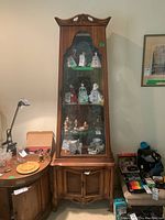 Full front view of cabinet showing overall condition, wood finish, glass door, carved crest and lower cane panels