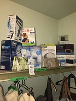 Wide shot showing all boxed and packaged items on shelf and hanging women's items beneath