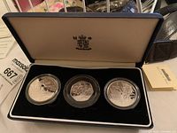 Three silver proof coins in capsules displayed in a blue velvet case with cream interior lining. Front view shows coin engravings and Royal Canadian Mint logo inside lid.