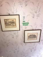 Two framed prints hanging on wall showing architectural scenes by Dorothy Clark McClure