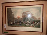 Clear frontal photo of framed engraving showing riders on horses surrounded by hunting dogs in a naturalistic setting with trees and sky background.