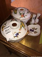 Two large Royal Worcester Evesham oven-to-table dishes with lids, salt and pepper shakers, and a small dish shown on wooden surface.