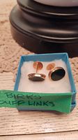 Pair of cufflinks in a blue gift box with handwritten Birks label