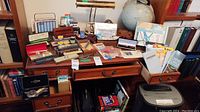 Overview of desk top with lamp, pens, pen cases, slide rules, maps, globe and books