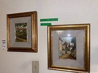 Two framed paintings wall-mounted showing both artworks