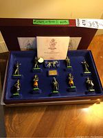Figure box set displaying ten Royal Irish Rangers soldier and drummer figurines plus a dog figure and included booklet inside a velvet-lined box.