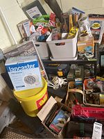 Photo showing overall assortment of tools, hardware, and boxed items including Lancaster fan heater and yellow bucket.