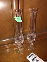 Photo showing two slender Waterford crystal vases with diamond-cut pattern near the base, placed on wooden shelf with green sticker showing 9 inch measurement.