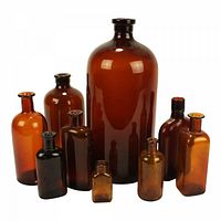 Various sizes of ribbed and plain amber and brown apothecary bottles arranged with the largest in the back and smaller in front