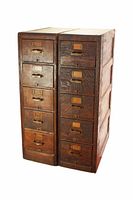 Both oak filing cabinets side by side, showing six drawers each with brass handles and label holders.