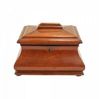 Wooden box with lock, curved sides, and stepped lid.