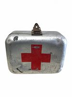 Front view of the rectangular metal first aid box with red cross symbol on top lid and latch in center