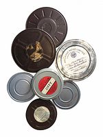 Top view of assorted film cans including brown and silver with labels and tape