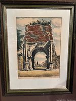 Framed print of Roman arch ruins labelled 'Arch of Drusus' with artist signature below, in a classic wood frame with cream and green mats.
