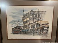Full view of framed print showing street scene, buildings and vintage vehicles.