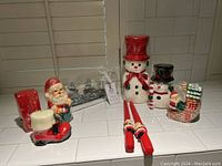 Photo showing all Christmas-themed candles arranged together including Santa, snowmen, boot, stocking, tapered and packaged candles