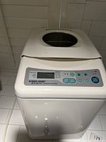 Top view of the breadmaker showing control panel, buttons, and transparent lid window
