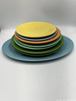 Stack of Fiesta plates showing different sizes and colors including yellow, turquoise blue, green, and orange.