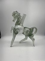Side view of the clear glass horse decanter, showing detailed mane and tail with one front leg lifted.