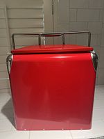 Front side showing bright red metal cooler with smooth finish and handle.