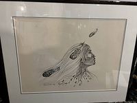 Framed black and white numbered print by Raymond Judge showing a Native American figure with feathers.
