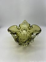 Full view of green glass dish from the top showing its organic shape and translucent chalet green color.