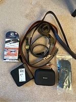 Full lot overview including belts, watch, gloves, and cases on carpeted floor.