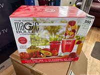 Box front showing Magic Bullet logo, red base unit, and images of chopped and blended food items. 17 piece set mentioned.